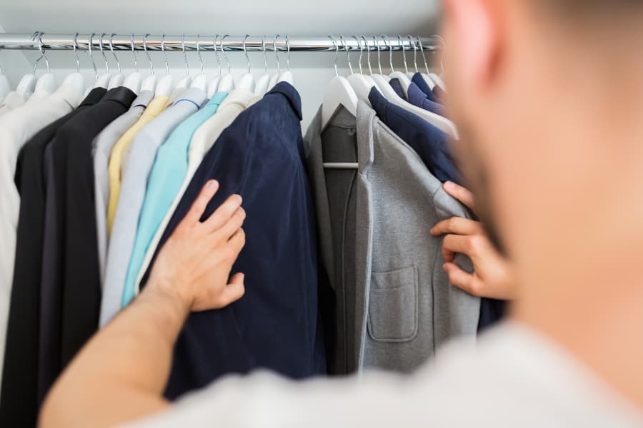 Man looking through closet at suit jackets